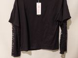 un t-shirt noir à manches en dentelle suspendu à un cintre