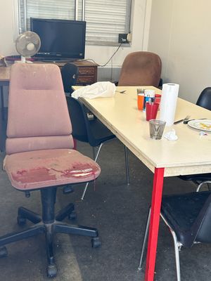 a desk with a chair and a fan in a room