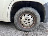 a white truck with a flat tire on the road