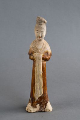 une vieille figurine représentant une femme tenant un livre dans ses mains