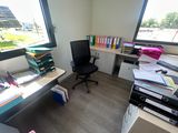 a desk with a chair and a computer on it
