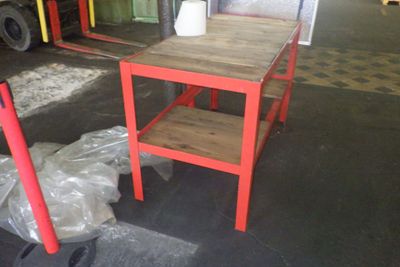 une table rouge et une chaise rouge dans un entrepôt