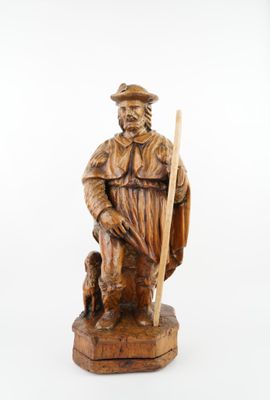 statue en bois sculpté représentant un homme muni d'un bâton et accompagné d'un chien
