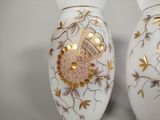 two white vases with gold designs on them