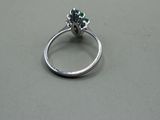a silver ring with a green flower on it