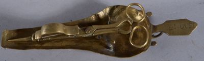 un objet doré sur lequel figure une paire de ciseaux