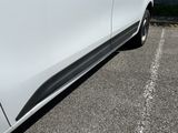 the side of a white car parked in a parking lot