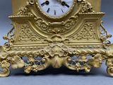 a gold clock sitting on top of a table