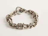 gros plan d'un bracelet en argent sur une surface blanche