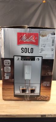 un carton contenant une machine à café posé sur une table