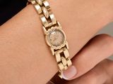 une femme portant un bracelet en or et une montre au poignet