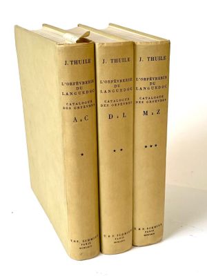 three books sitting on top of each other on a white surface