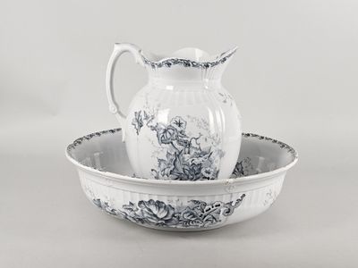 un saladier blanc et bleu surmonté d'un pichet