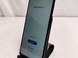 a close up of a phone on a stand on a bed
