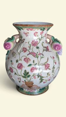 a white vase with pink flowers on it on a white background