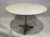 une table en marbre blanc avec un piètement en métal, sur fond blanc