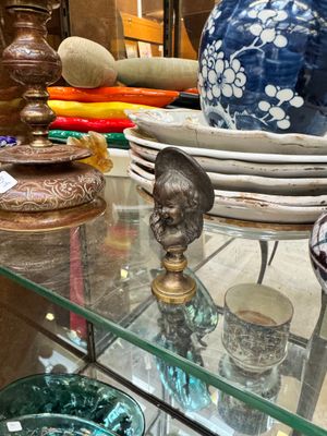 a glass table topped with bowls and vases on it