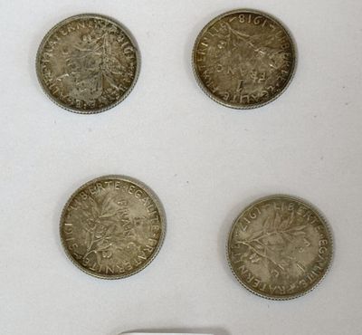 six pièces de monnaie britanniques différentes présentées dans une vitrine posée sur un support blanc