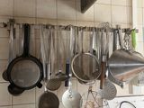 many pots and pans hanging on the wall