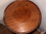 a small table with a wooden top in a corner