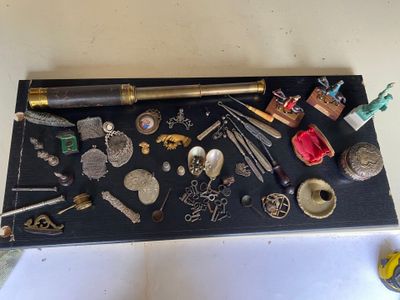 un plateau noir sur lequel sont disposés de nombreux objets divers