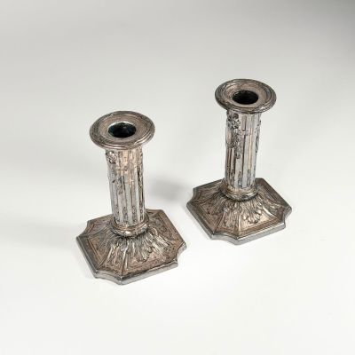 pair of antique silver candlesticks on a white background