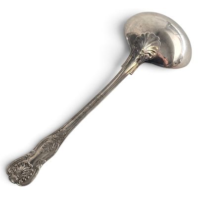 a silver spoon with a flower on it on a white surface