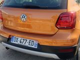 the rear end of an orange vw golf parked on the side of the road