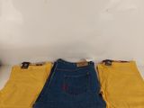 two pairs of yellow and blue jeans sitting on top of a white table
