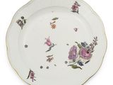 une image représentant une assiette décorée de fleurs et de feuilles