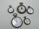 five different types of pocket watches displayed on a table