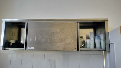 a metal cabinet with a mirror above it in a bathroom