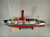 une maquette de bateau rouge et vert posée sur une table