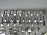 a lot of silver spoons and forks laid out on a table