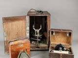 trois vieilles caisses en bois contenant chacune une machine à coudre