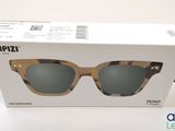 l'étui d'une paire de lunettes de soleil est ouvert sur une surface blanche