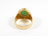 a close up of a gold ring with a green stone