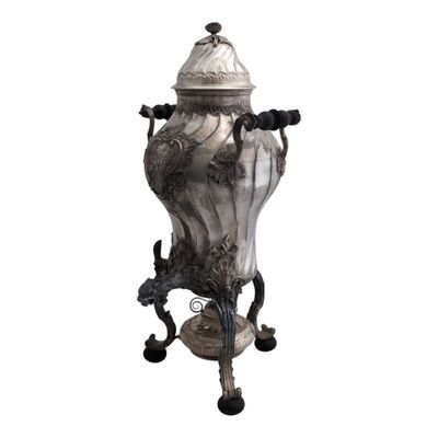 a silver vase on a stand on a white background