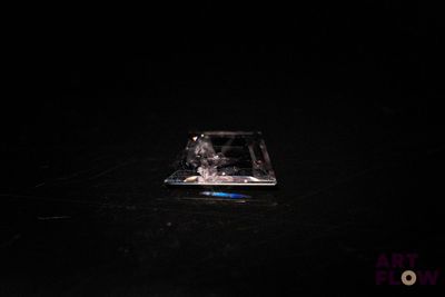 un petit morceau de verre posé sur une surface noire