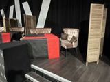 a stage set up with chairs and a table with a red runner
