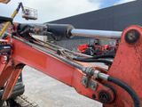 a red excavator that is sitting in a parking lot