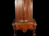 an old wooden chair with a carved back and a wooden seat