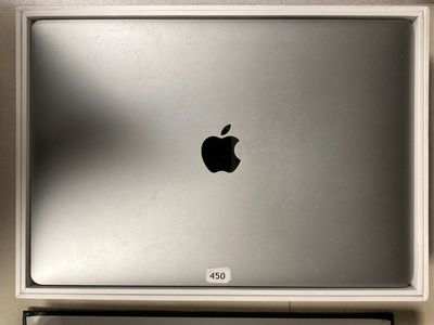 un ordinateur portable Apple posé sur un bureau, à côté d'un clavier