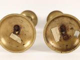 pair of antique brass candlesticks with labels on them
