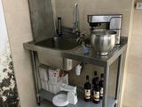 a kitchen with a sink and a counter with a lot of stuff on it