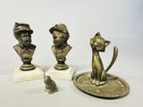 three figurines of a cat and a dog on a plate