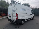 a white van parked in a parking lot with trees in the background