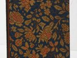un vieux livre à la couverture bleue ornée d'un motif floral