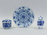 a blue and white plate and two small vases and a bowl