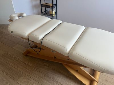 a massage table that is sitting on a wooden stand